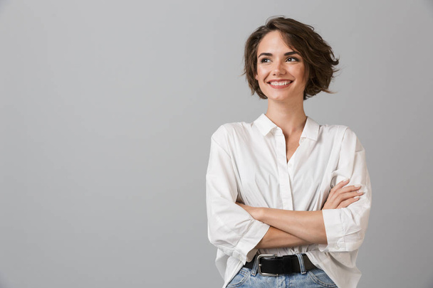 Image of happy young business woman posing isolated over grey wall background. - 写真・画像