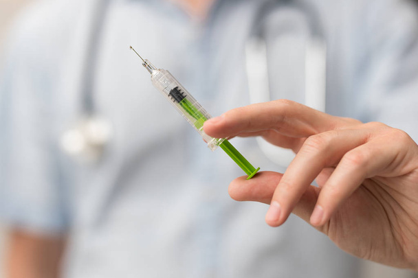 Syringe with green medical injection in hand  - Photo, Image