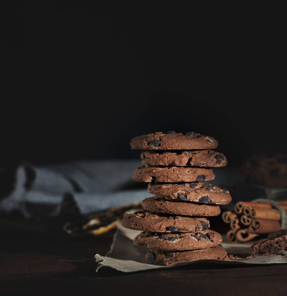stack of round chocolate chip cookies on brown paper, empty space  - Fotó, kép