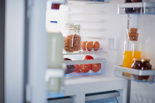 Картина відкритого холодильника з продуктами всередині
. - Фото, зображення