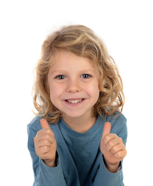 lindo niño en jersey azul mostrando pulgares hacia arriba aislado sobre fondo blanco
 - Foto, imagen