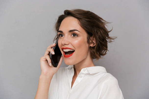 Photo of european woman 20s smiling and speaking on mobile phone - Fotó, kép