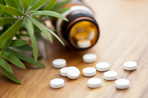 Medicamento homeopático con tabletas - Botella con tabletas en la mesa de madera
 - Foto, imagen