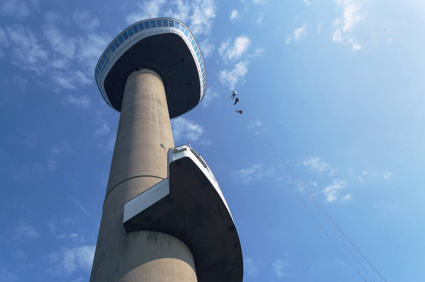 Rotterdam, The Netherlands, October 6, 2018: View from below on Euromast with blue sky on background and  bungy jumping people - Fotografie, Obrázek