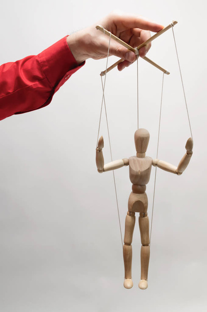 Concept of control. Marionette in woman's hand. - Foto, afbeelding