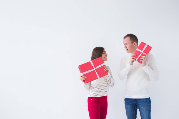 Різдво, свята, день Святого Валентина і день народження концепції - щасливий чоловік і жінка тримає коробки з подарунки на білому тлі з скопіювати простір - Фото, зображення