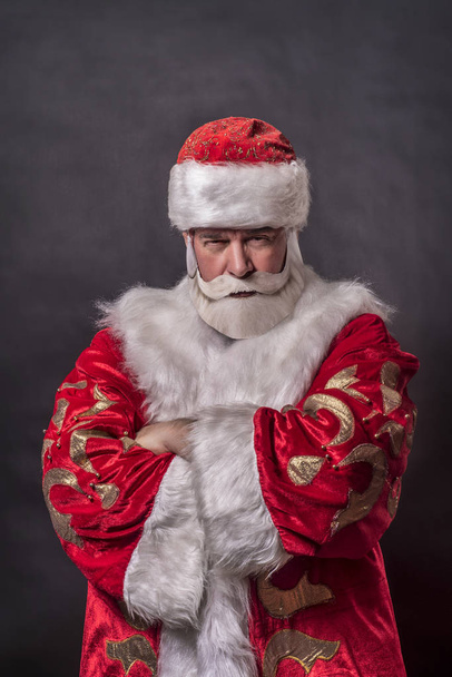 Un homme riche âgé déguisé en Père Noël et un roi sur un fond gris
 - Photo, image