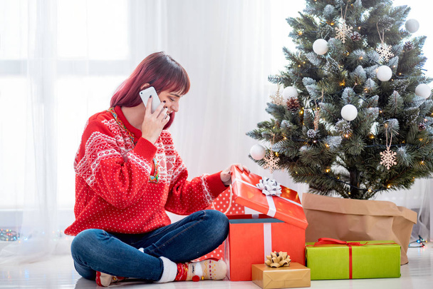 Young woman call mobile phone by Christmas tree - Foto, Imagem