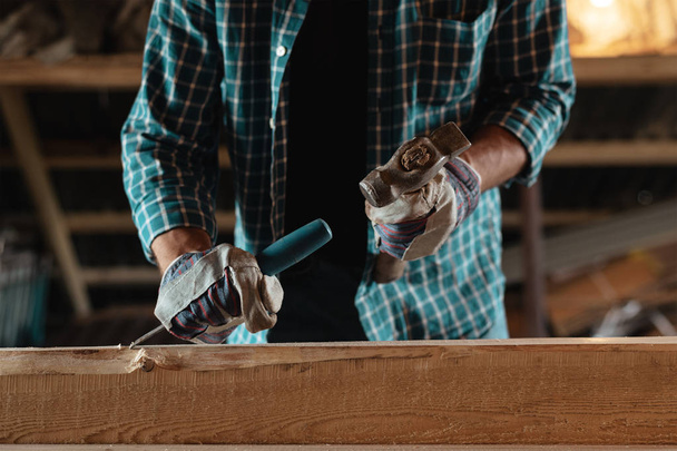 Carpintero con un martillo y cincel maneja la madera. Únete al trabajo en el taller. Taller casero, con sus manos
 - Foto, imagen