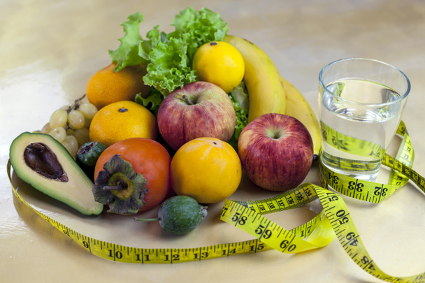 Concepto de dieta. Verduras y frutas: Aavakado, higos, feijoa, limpieza del cuerpo, alimentación saludable, cinta métrica de cintura
 - Foto, Imagen