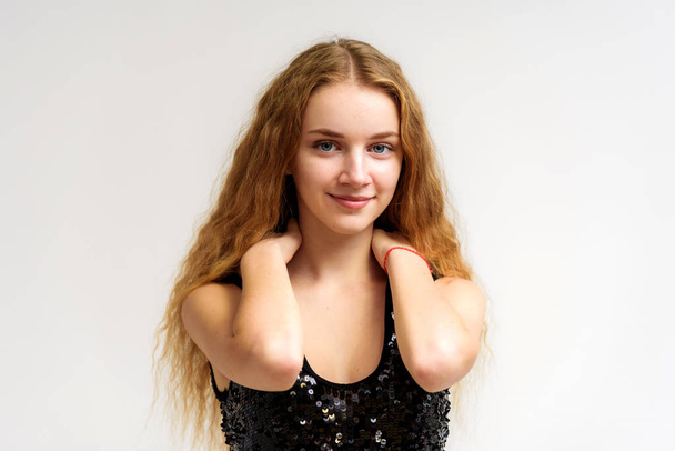 Studio portrait of a beautiful girl blonde teenager on a white background in various poses. She is standing with different emotions right in front of the camera, smiling and looking happy. - Foto, imagen