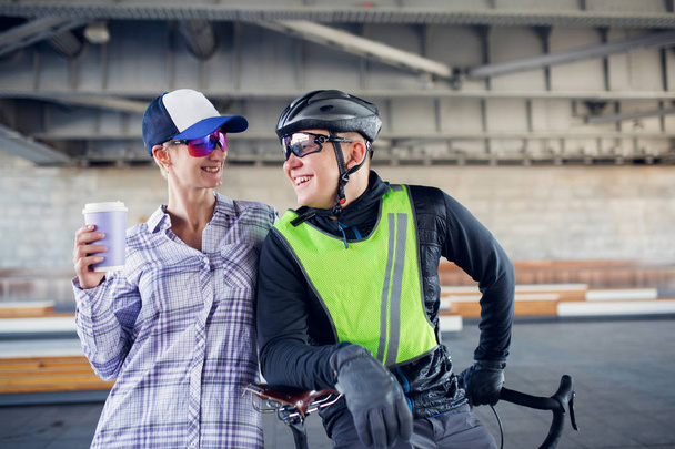 Photo of happy sporty woman and man with bicycle on blurred background - Φωτογραφία, εικόνα