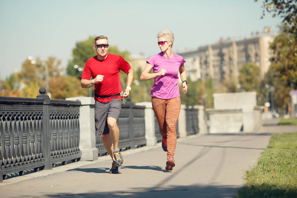 Image of sport couple running along promenade - Photo, Image