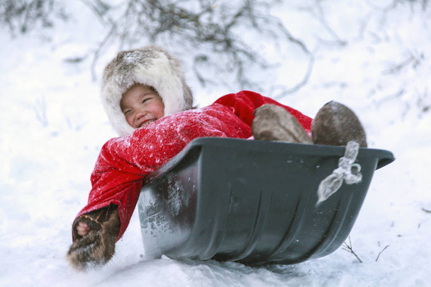 A resident of the tundra, indigenous residents of the Far North, tundra, open area, children ride on sledges, children  in national clothes,Little girl in red clothes - Photo, Image