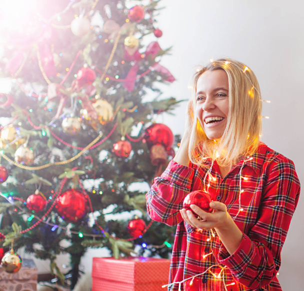 Happy woman wrapped in Christmas lights - Zdjęcie, obraz