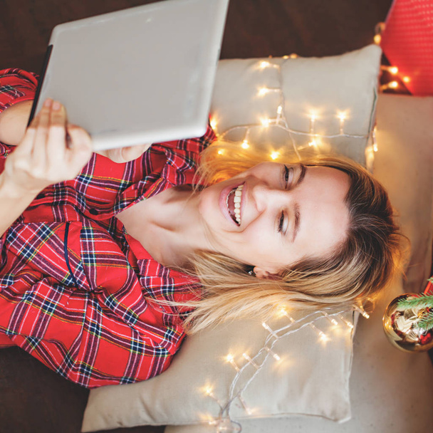 Woman with tablet near christmas tree - Foto, imagen