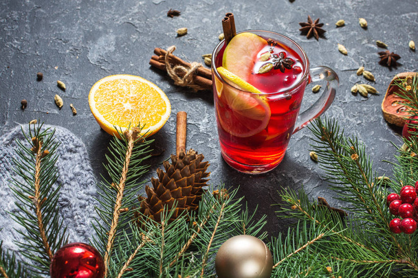 Christmas mulled wine with spices and orange slices on stone table. Traditional drink on winter holiday. - 写真・画像