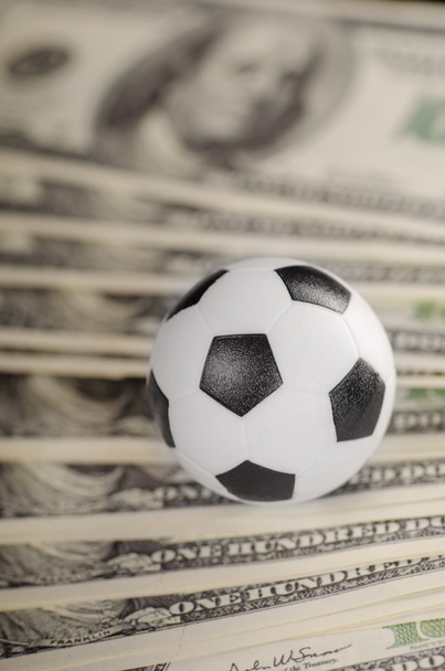Soccer ball on background of dollars - Foto, Imagen