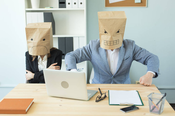 Bedrijf, emoties en mensen concept - vrouw en man dragen van de pakketten op hun hoofd met afgebeeld emoties woede en angst - Foto, afbeelding