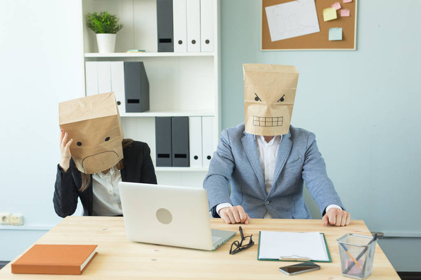 Conceito de negócios, emoções e pessoas - Dois trabalhadores irritados e exaustos no local de trabalho. Pessoas usando os pacotes em suas cabeças com emoções retratadas
 - Foto, Imagem