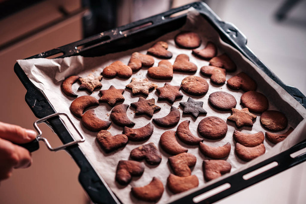 Holding baking tray with burnt gingerbread cookies - Photo, Image