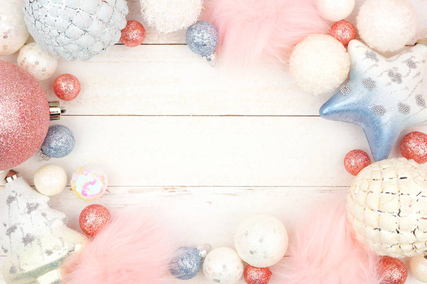 Marco de adorno de Navidad azul y rosa pastel sobre un fondo de madera blanca brillante
 - Foto, imagen