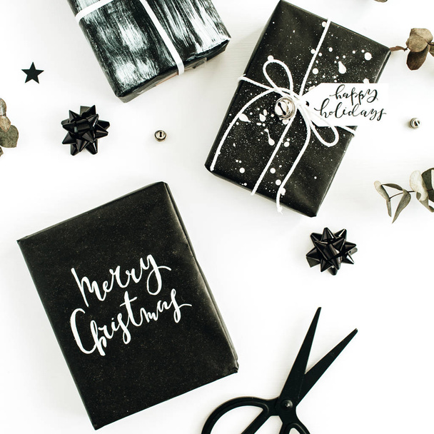 Μαύρο σπιτικά δώρο κουτιά και διακοσμήσεις σε άσπρο φόντο. Χαρούμενα Χριστούγεννα έννοια  - Φωτογραφία, εικόνα
