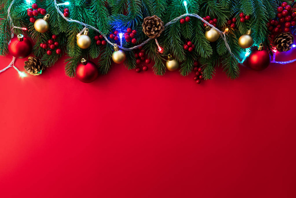 Koncepcja tło Boże Narodzenie. Widok z góry Boże Narodzenie prezent pole czerwone skarpetki z świerk oddziałów, szyszki, czerwone jagody i dzwon na czerwonym tle. - Zdjęcie, obraz
