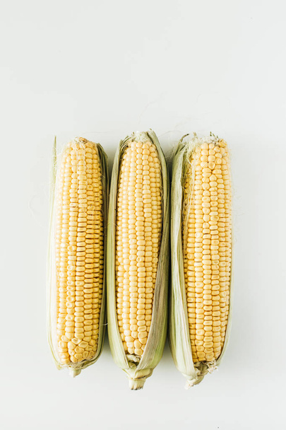 Espigas cruas de milho, conceito vegetariano, vista superior
  - Foto, Imagem