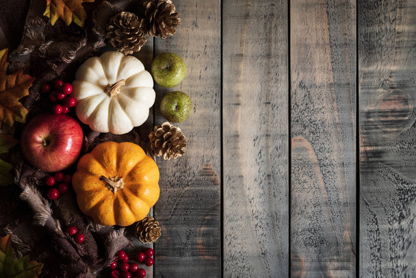 Őszi juharlevelek, a sütőtök és a piros bogyós gyümölcsök a régi fa háttér felülnézet. Hálaadás napja koncepció. - Fotó, kép