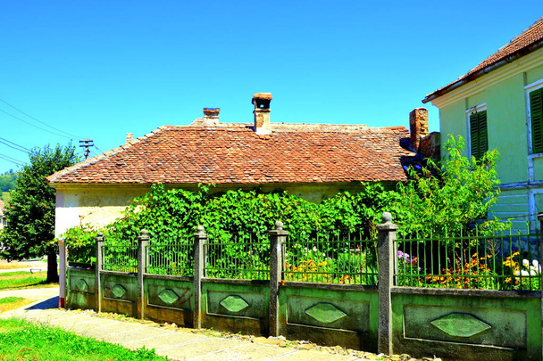Typowy krajobraz i chłop domy w wiosce Merghindeal - Mergenthal, Transylwania, Rumunia. Osada została po raz pierwszy certyfikat w 1336, ale obronny kościół pochodzi z drugiej połowy XIII wieku. - Zdjęcie, obraz