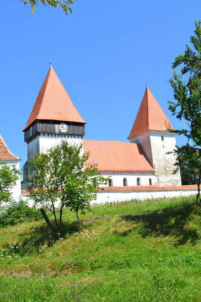 Chiesa fortificata sassone medievale nel villaggio Merghindeal-Mergenthal, Transilvania, Romania. L'insediamento fu certificato per la prima volta nel 1336, ma la chiesa fortificata risale alla seconda metà del XIII secolo
. - Foto, immagini