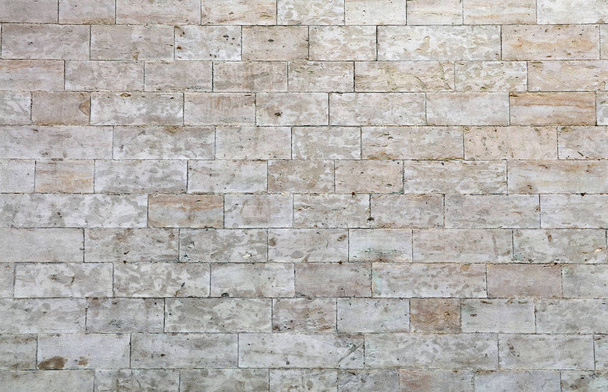 Wall of white and gray adarce travertine stone brick blocks, close up background texture, side view - 写真・画像
