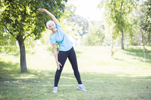 Vezető nő edzés a parkban. Egészség, az idős hölgy a nyugdíjas fogalma. - Fotó, kép