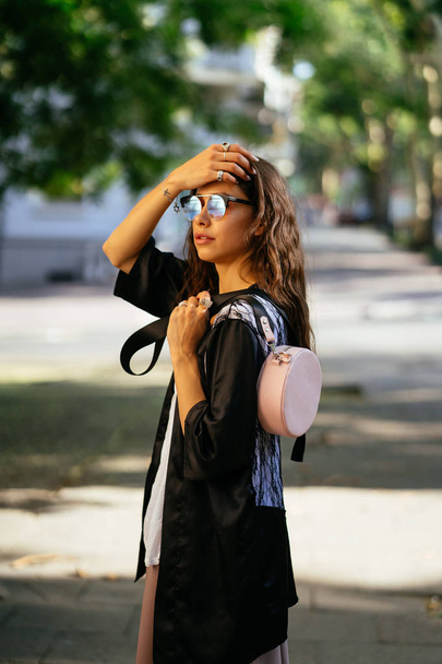Chica posando para la cámara con una bolsa femenina
 - Foto, imagen
