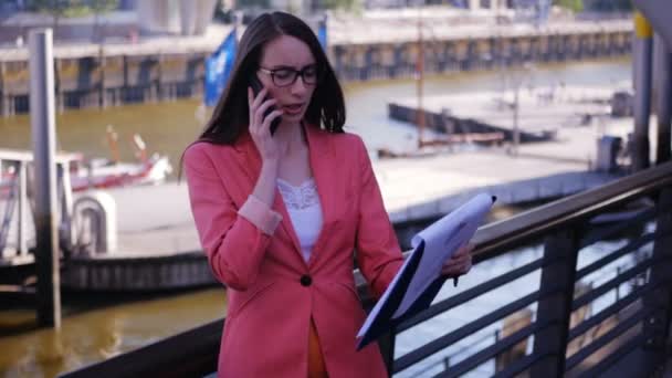 Een vrouwelijke executive is in rep en roer door een contract en een geschil heeft met de partners op de telefoon - Video