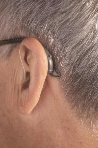 Homem idoso surdo vestindo moderno aparelho auditivo digital de alta tecnologia no ouvido
. - Foto, Imagem