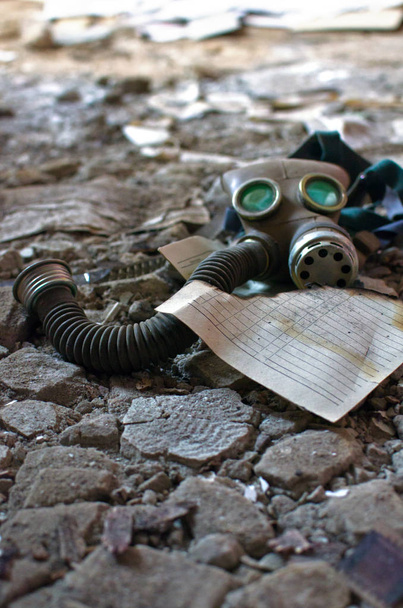 gas mask lies next to a sheet of old burnt paper - Photo, Image