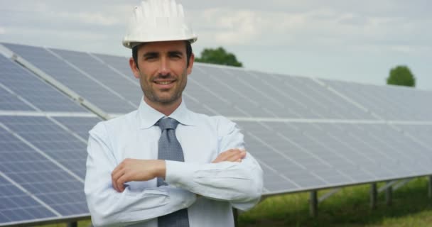 video of Caucasian man standing at eco solar panels with arms crossed and looking at camera  - Metraje, vídeo