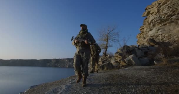 Ozbrojení vojáci chůze u jezera - Záběry, video