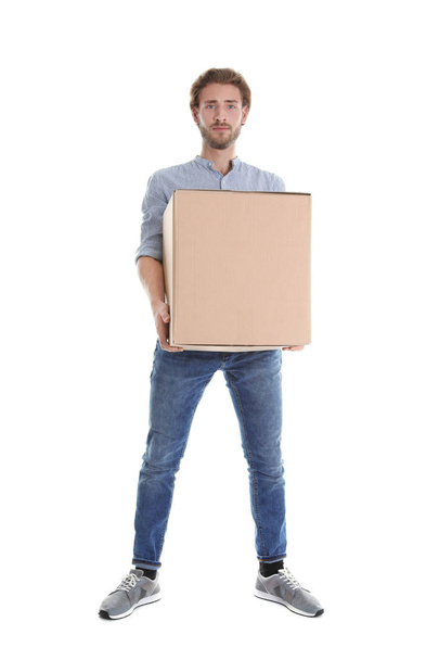 Full length portrait of young man carrying heavy cardboard box on white background. Posture concept - Photo, Image