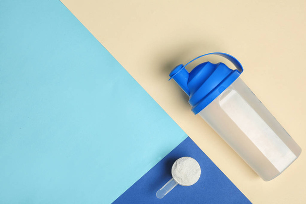 Flat lay composition with protein powder, bottle and space for text on color background. Preparing shake - Photo, image