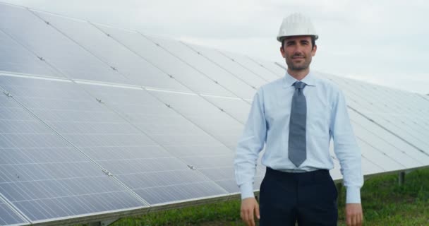 slow motion video of Caucasian man in helmet standing at eco solar panels with arms crossed and looking at camera  - Πλάνα, βίντεο