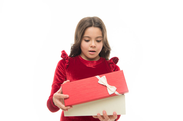 Child excited about unpacking her gift. Small cute girl received holiday gift. What is inside. Best toys and christmas gifts for kids. Kid little girl in elegant dress curly hairstyle hold gift box - Foto, Imagem