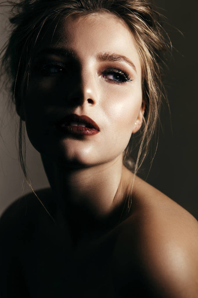 Art portrait of a beautiful girl with make-up, clean skin and flowing hair. - Photo, Image