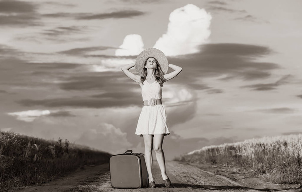 ragazza in abito bianco con valigia a strada rurale
 - Foto, immagini