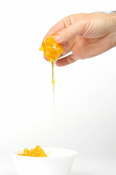 miel de la mano drena en un plato blanco
 - Foto, Imagen