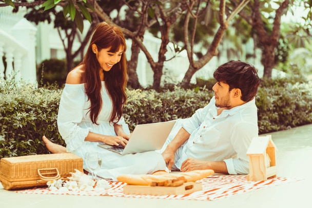 Feliz pareja joven ir de picnic y citas en el parque en verano
. - Foto, Imagen