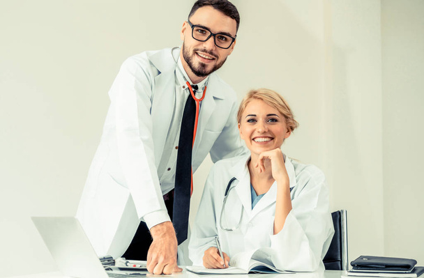 Glückliches Arztporträt in der Krankenhauspraxis mit einem anderen Arzt, der neben ihr steht. Teamarbeit der Mediziner. - Foto, Bild