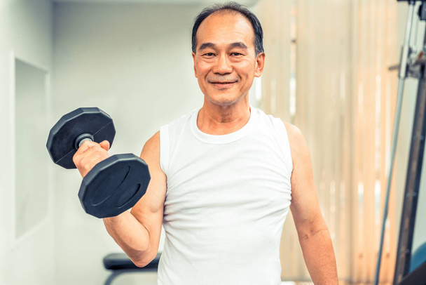 Homme âgé haltère de levage dans la salle de fitness. Mode de vie sain senior
. - Photo, image